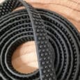 Close-up of a coiled Super-grip Biothane Training Tab / Obedience Lead 51cm with a raised dot pattern, placed on a light wooden surface—perfect for training and obedience sessions.