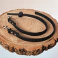 A Super-grip Biothane Training Tab / Obedience Lead 51cm with metal clasps is coiled on a round wooden slice with visible tree rings, set against a light background.