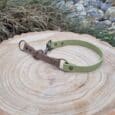 Handmade quick-snap customisable dog collar in sage green and brown BioThane, displayed on wooden log with natural outdoor setting.