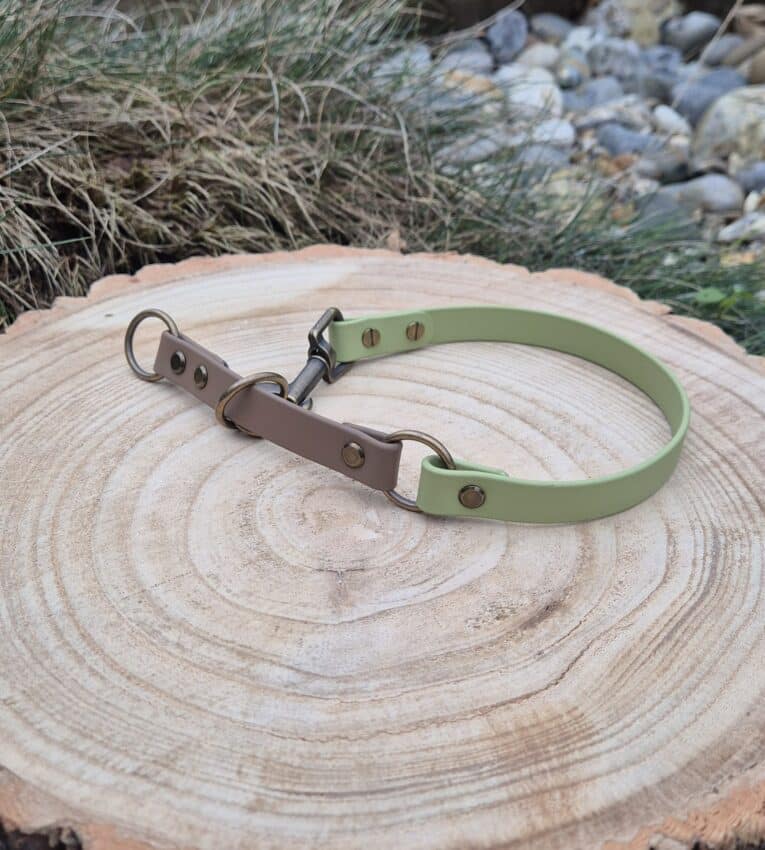 Handmade quick-snap customisable dog collar in sage green and brown BioThane, displayed on wooden log with natural outdoor setting.
