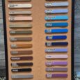 A colour chart with 34 labelled samples—shades of white, brown, grey, blue, and purple—perfect for choosing your Centre O-Ring Collar / Gundog Collar. Displayed on a cork board with rocks and wood panels in the background.