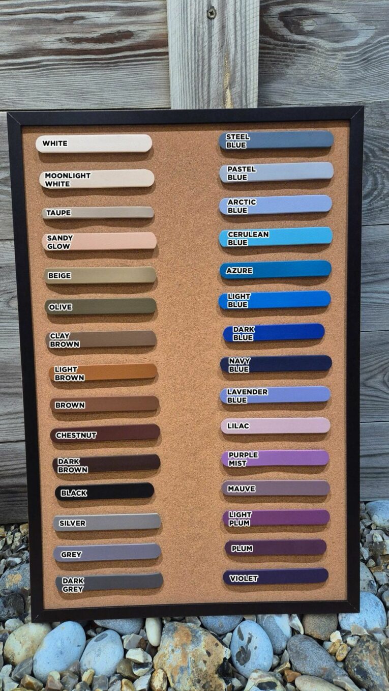 A colour chart with 34 labelled samples—shades of white, brown, grey, blue, and purple—perfect for choosing your Centre O-Ring Collar / Gundog Collar. Displayed on a cork board with rocks and wood panels in the background.