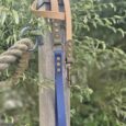 Navy BioThane lead with antique brass fittings and beige handle, displayed against garden foliage.