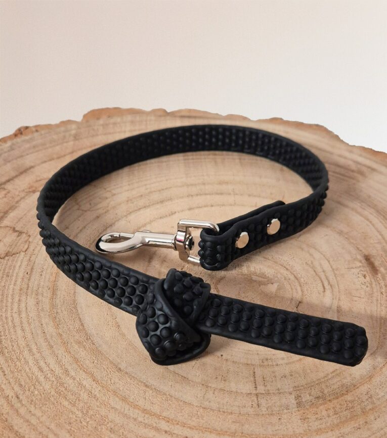 Black Super-Grip Waterproof Training Tab Obedience Lead with textured grip surface and nickel hardware on wooden base.
