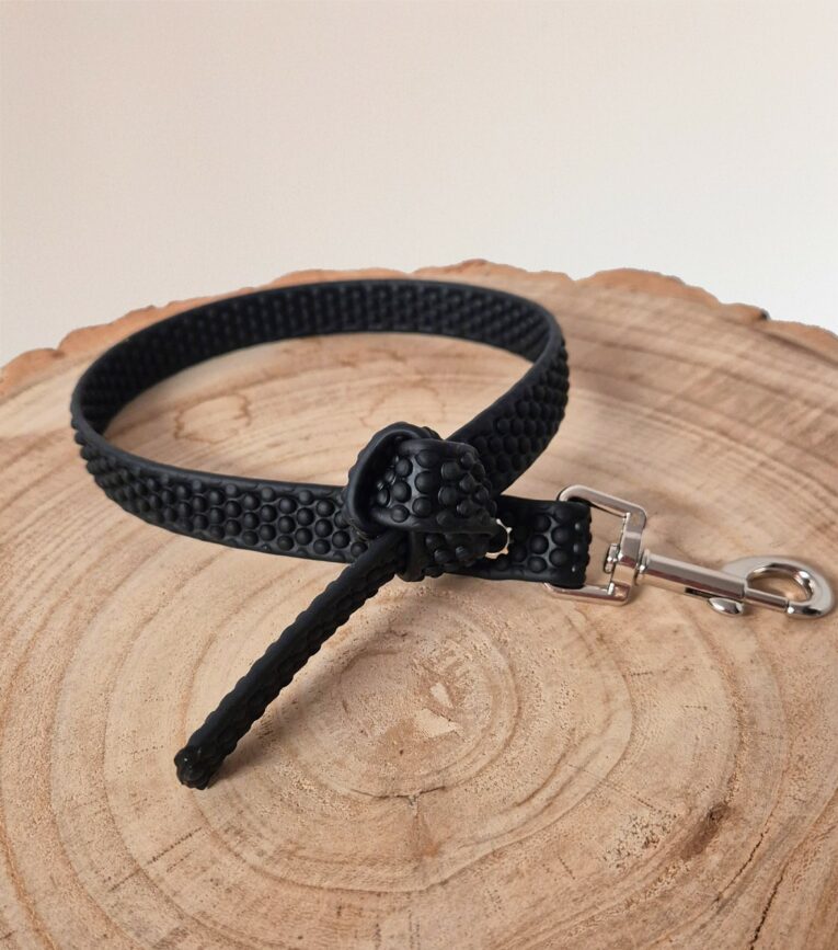 Black Super-Grip Waterproof Training Tab Obedience Lead with textured grip finish and nickel hardware, coiled on wood.