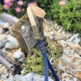 Aubreys x Lutchfords collaboration lead in navy and beige, displayed on weathered wood with purple flowers behind.