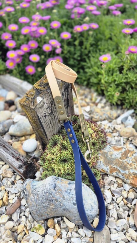 Aubreys x Lutchfords collaboration lead in navy and beige, displayed on weathered wood with purple flowers behind.