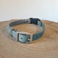 Light blue BioThane quick-snap customisable dog collar strap with nickel hardware, displayed on natural wood.