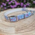Adjustable BioThane martingale half-check collar with vibrant floral print and nickel hardware, displayed on wooden surface.
