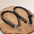 Two black Super-grip Waterproof Training Tab Obedience Leads with textured grip handles and nickel hardware, displayed on natural wood.