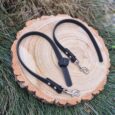 Black super-grip waterproof training tab obedience lead coiled on wood, displaying textured grip surface and nickel hardware.