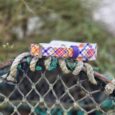Printed tapered hound collar in vibrant tartan pattern displayed on weathered rope, showcasing waterproof BioThane design.