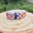 Waterproof tartan dog collar with navy hardware displayed on natural wood, featuring colourful diamond print design.