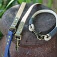 Three handmade dog leads in beige, navy and olive, featuring antique brass hardware and paracord detailing from the Aubreys x Lutchfords collaboration.