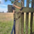Aubreys x Lutchfords paracord collar and BioThane lead in signature beige, navy and olive, displayed on rustic fence.