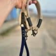 Hand holding Aubreys x Lutchfords collaboration paracord collar and BioThane lead in beige, navy and olive.