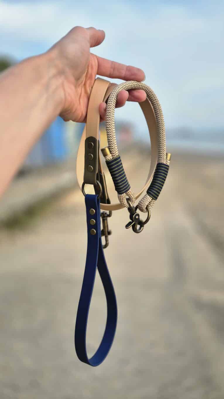 Hand holding Aubreys x Lutchfords collaboration paracord collar and BioThane lead in beige, navy and olive.