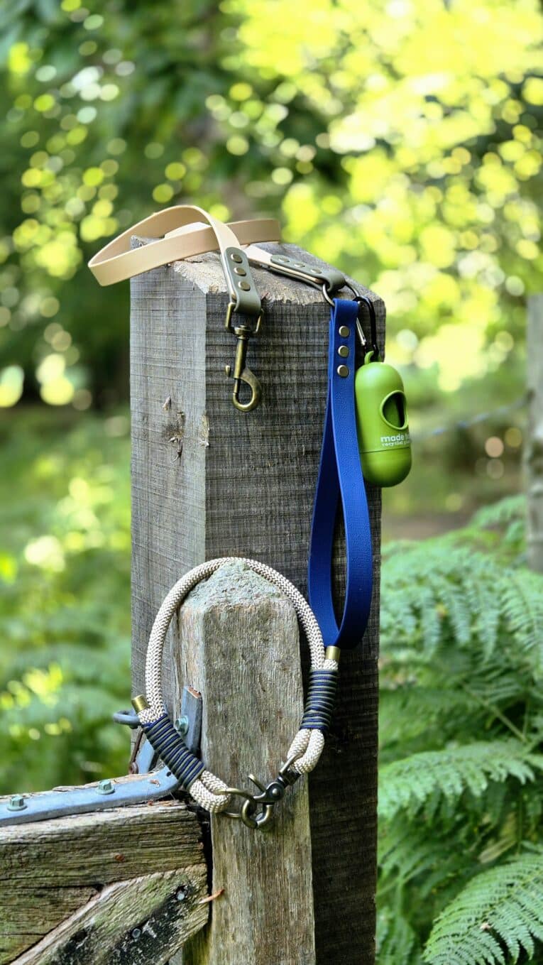 Aubreys x Lutchfords collaboration paracord lead with navy blue BioThane and antique brass hardware, displayed on wooden post.