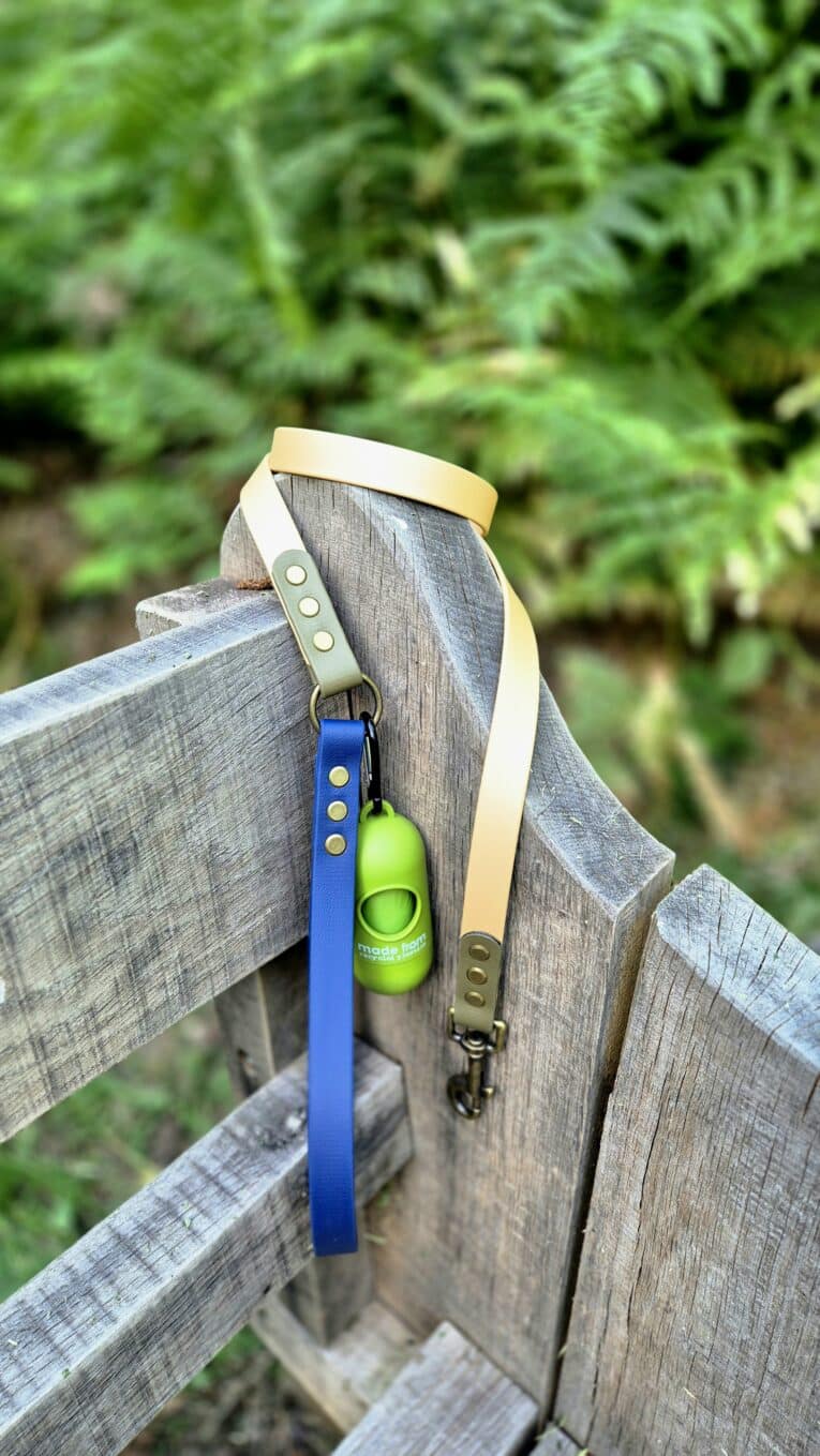 Aubreys x Lutchfords collaboration lead in navy and beige with antique brass hardware, draped over weathered wood.