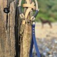 Aubreys x Lutchfords collaboration lead and collar set displayed on weathered wood, featuring beige paracord, navy BioThane, and antique brass hardware.