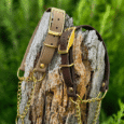 Adjustable martingale half-check collar in taupe and dark brown BioThane with brass hardware and chain detail, displayed on weathered wood.